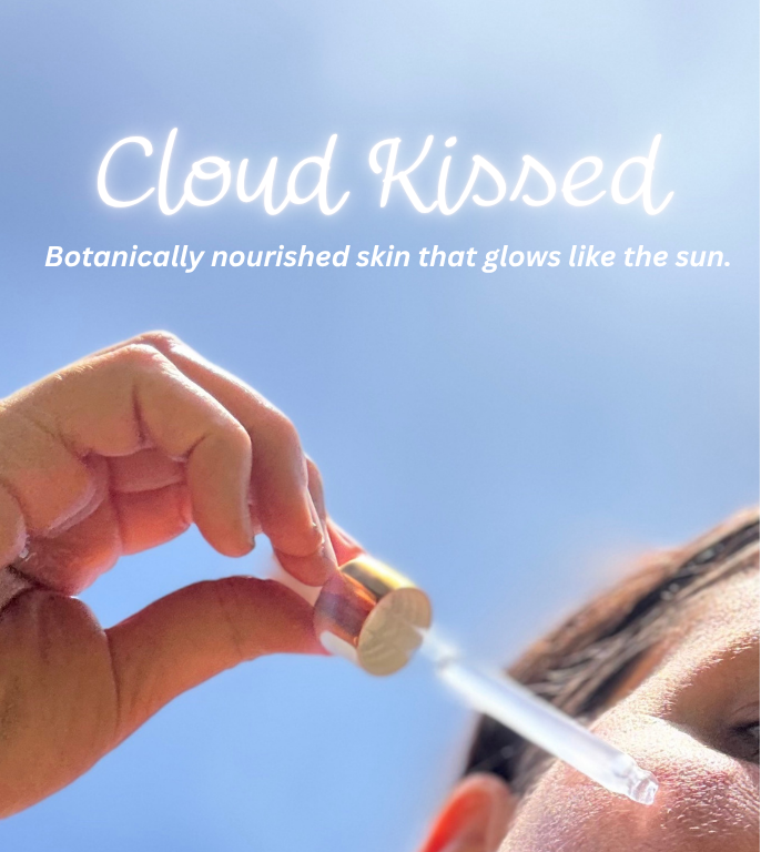 Hand holding a skincare product with 'Cloud Kissed' branding and text on a blue background